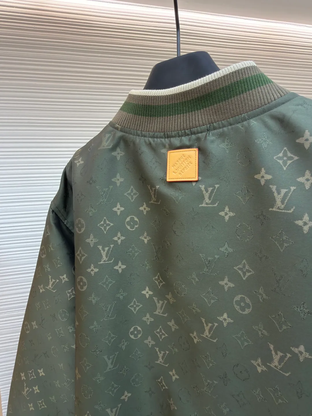 LOUIS VUITTON striped trim jacquard long-sleeved bomber jacket ●Original version: purchased and developed by 29237 ●Item number: 1682087-C05 ●Fabric: nylon fabric ●Technology: jacquard production ●Color: green ●Version: fitted version ●Weight: about 800 grams ●Size: S-M-L-XL ●Description: This Louis Vuitton baseball jacket is made of high-density jacquard satin fabric. The base is a polyester fiber blended material with a military green matte texture. The classic Monogram presbyopia pattern is woven into the fabric in the form of dark patterns of the same color through a special weaving process. The pattern texture is three-dimensional and presents a delicate illusion luster with the angle of light. High-precision jacquard weaving technology is used in the process to ensure the integrity and delicacy of the pattern. The body adopts a single-row metal snap closure design. The metal buckles are matte and distressed to echo the color of the body. The ribbed collar, cuffs and hem are made of two-color knitting technology. The elastic ribs have both stiffness and comfort, and are pre-shrunk to prevent deformation. The overall cut is a loose oversize version, and the splicing uses a combination of flat seams and hemming techniques. The interior is supplemented by smooth overlock sewing. Every stitch is even and fine, which fully reflects the brand's exquisite garment production technology and detail control. The overall wiring is straight and delicate, the fabric is comfortable and soft, and the color is consistent without color difference. It can be matched with the same style to create a fashionable look and control various occasions. Customized accessories, complete with three standards, same style for men and women!